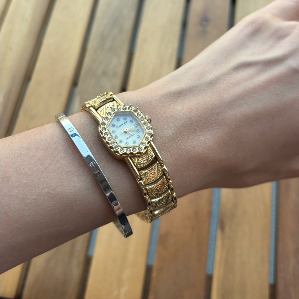 Ronica gold tone ladies watch with rhinestone accents.